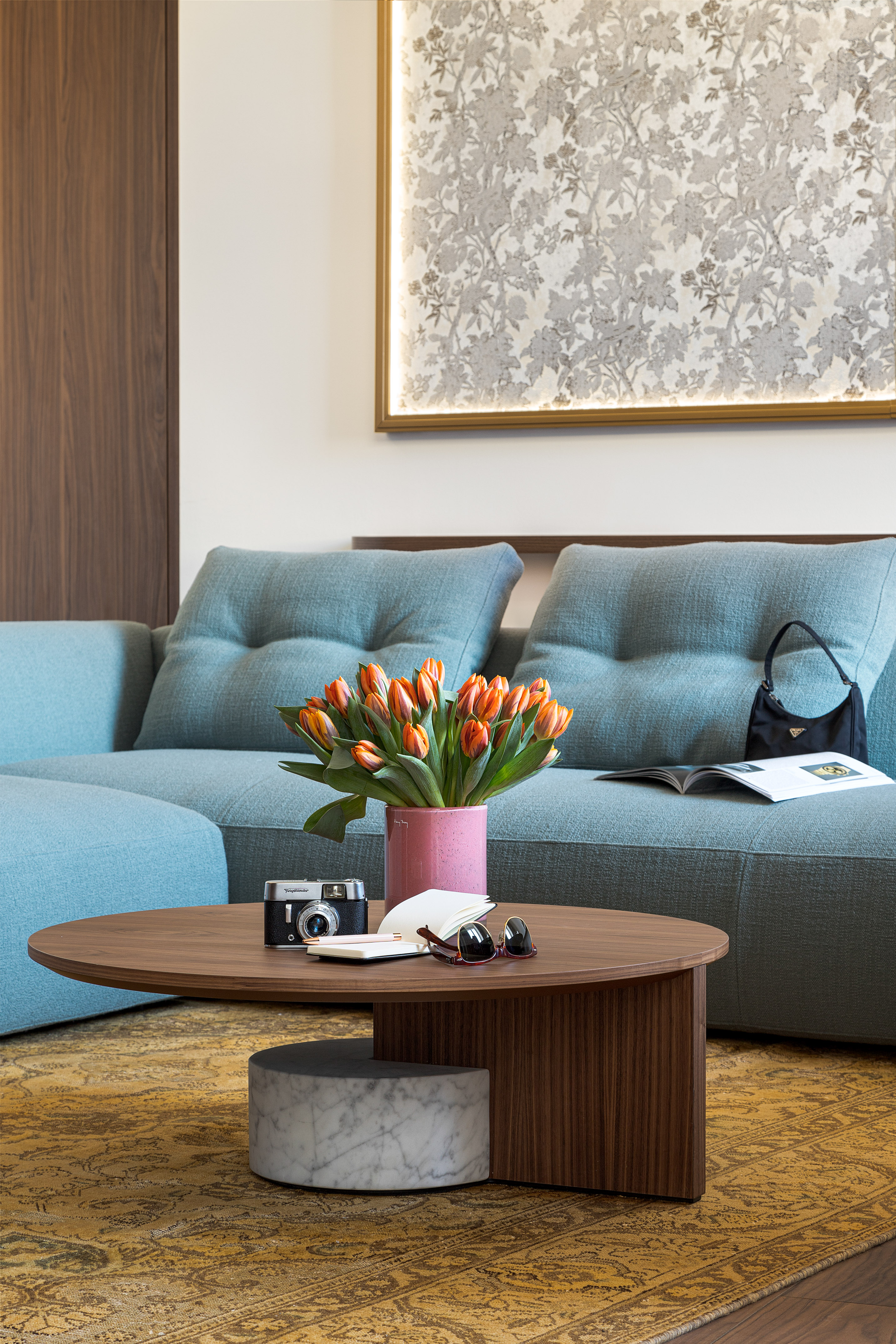 a couch with a vase of flowers and a camera