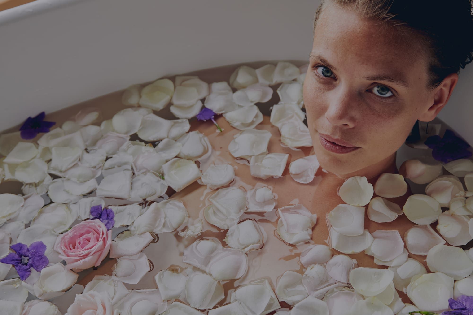 a woman in a bathtub with flowers