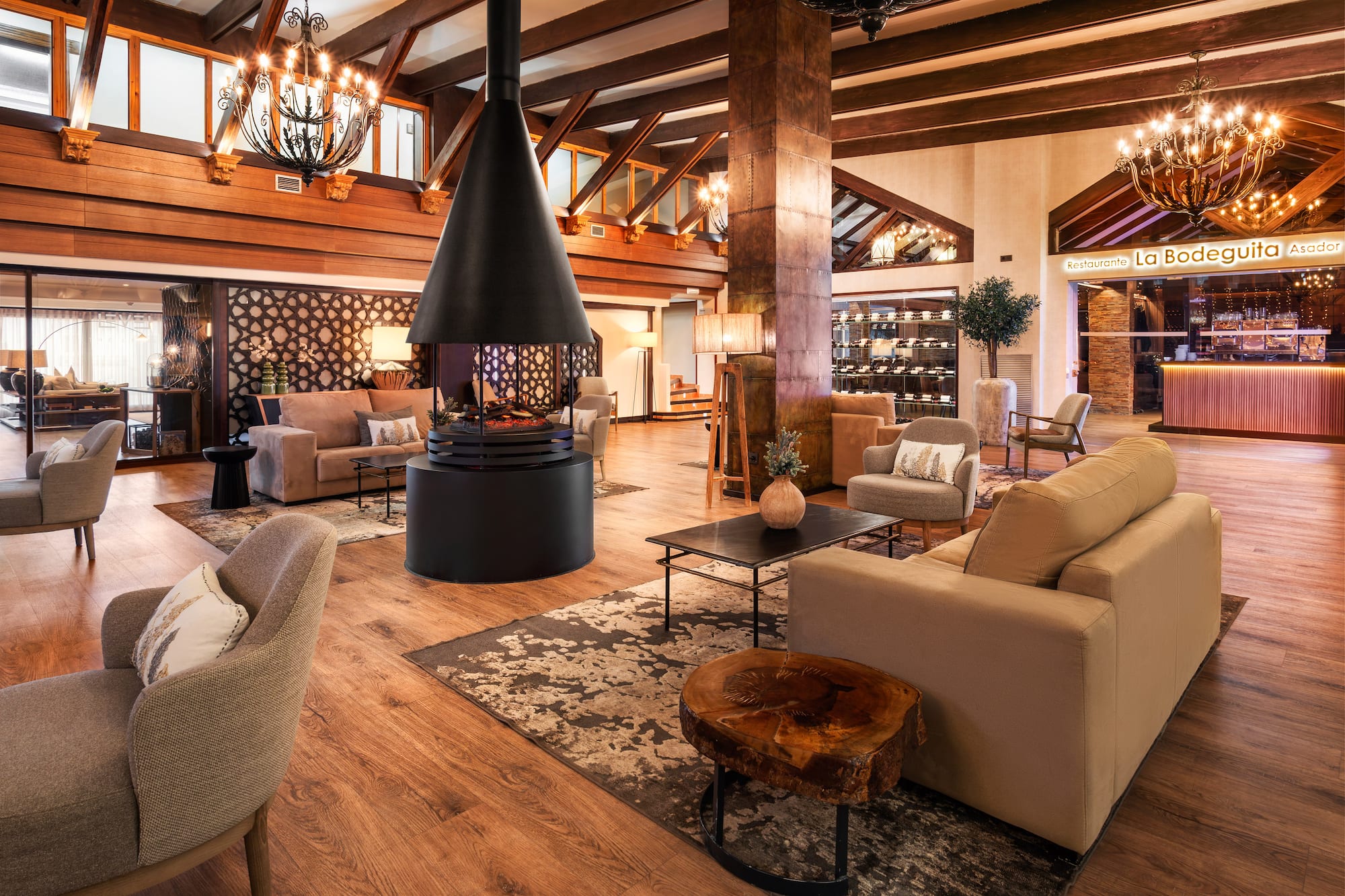 Hotel lounge with central fireplace, wooden beams, and inviting seating.