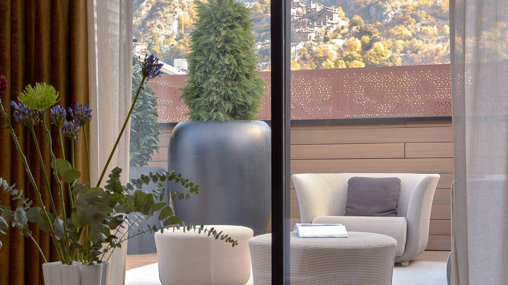 a room with a view of a mountain and a tree