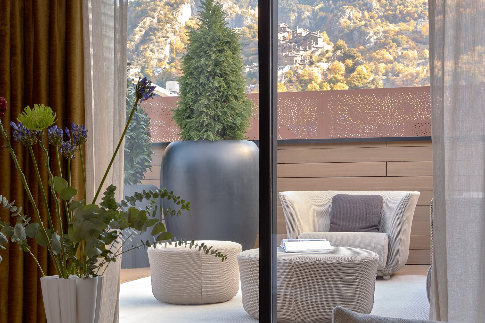 a room with a view of a mountain and a tree