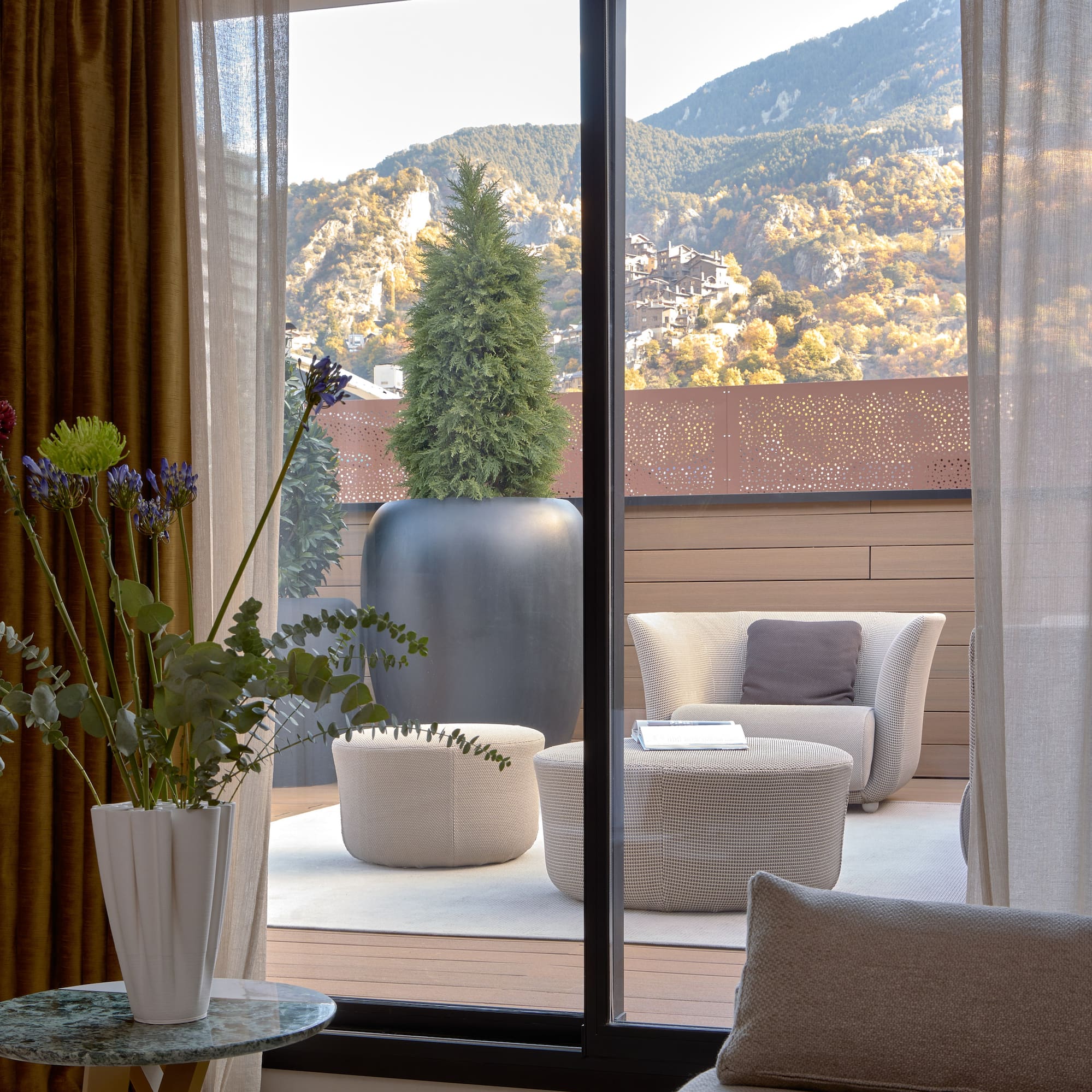 a room with a view of a mountain and a tree