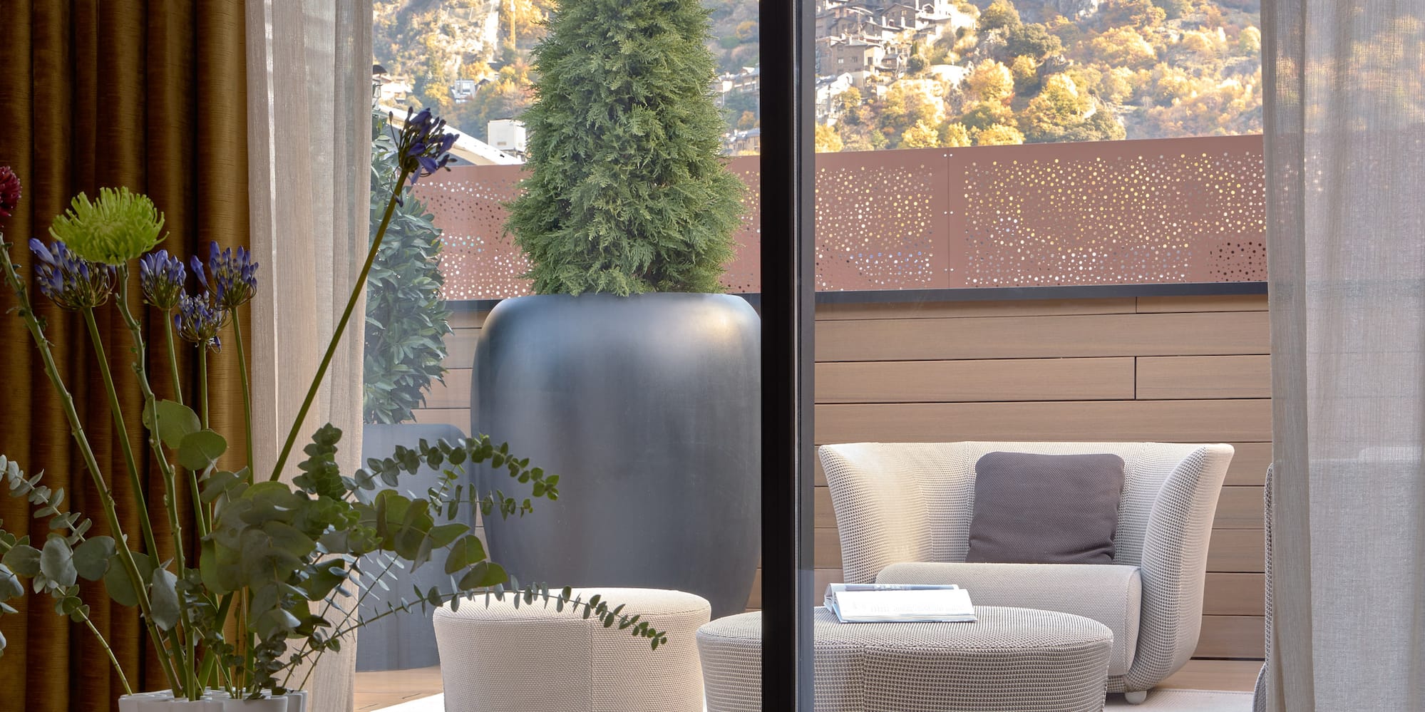 a room with a view of a mountain and a tree