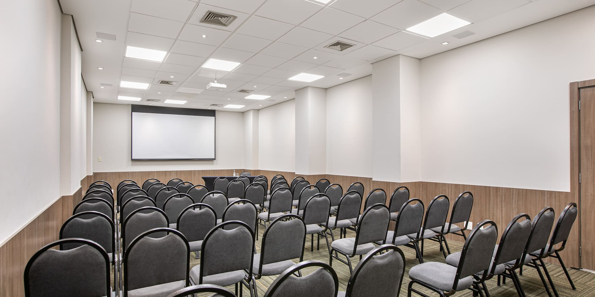 a room with chairs and a projector screen