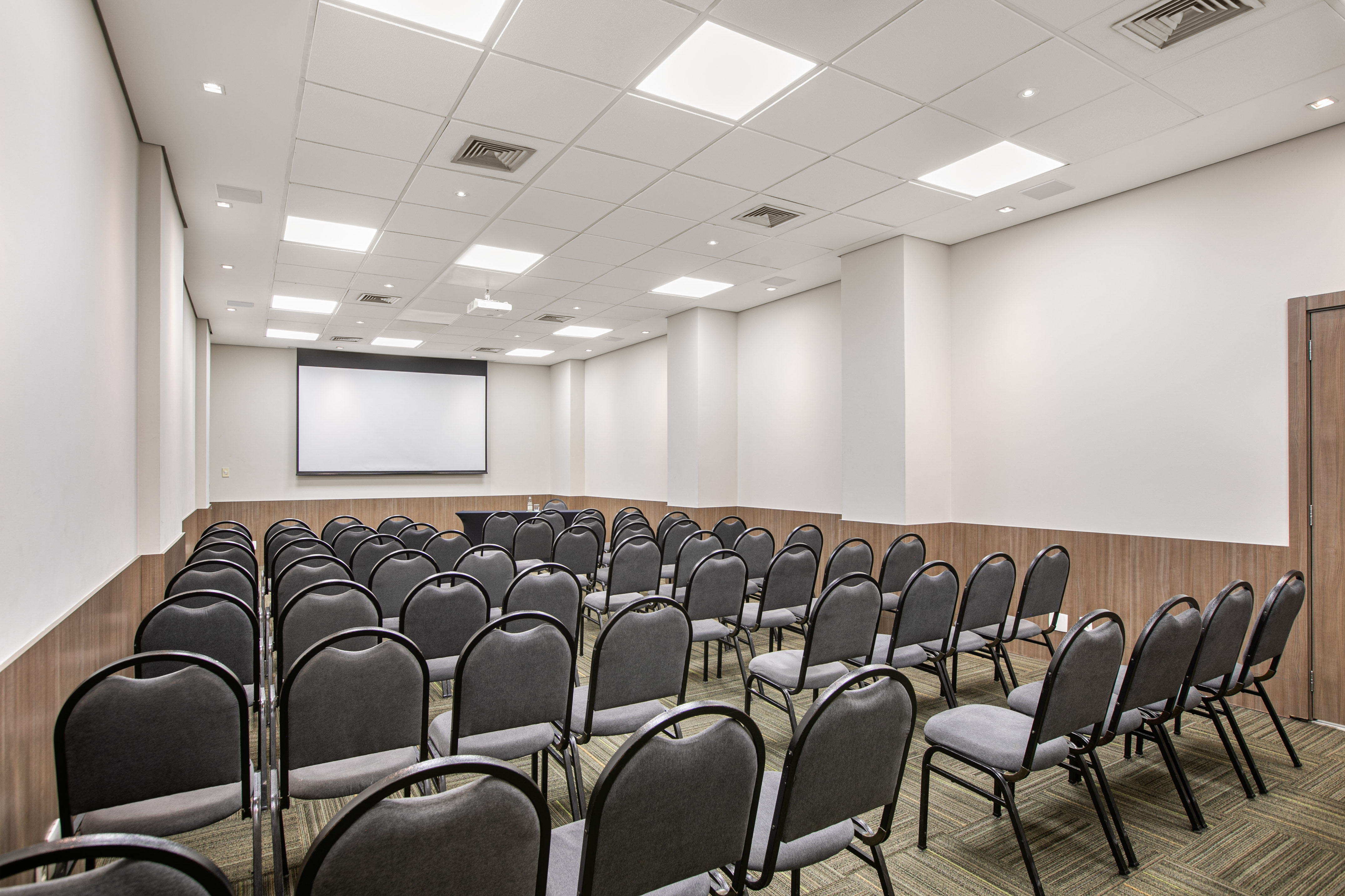 a room with chairs and a projector screen