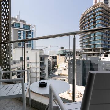 a balcony with a table and chairs and a city view