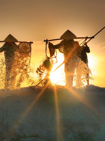 a group of people with conical hats holding fishing nets