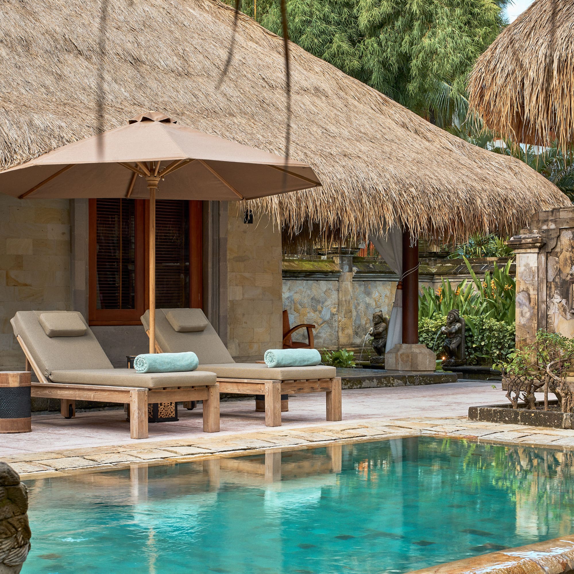 a pool with lounge chairs and umbrella by a building