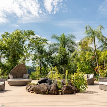 a patio with a fire pit and chairs