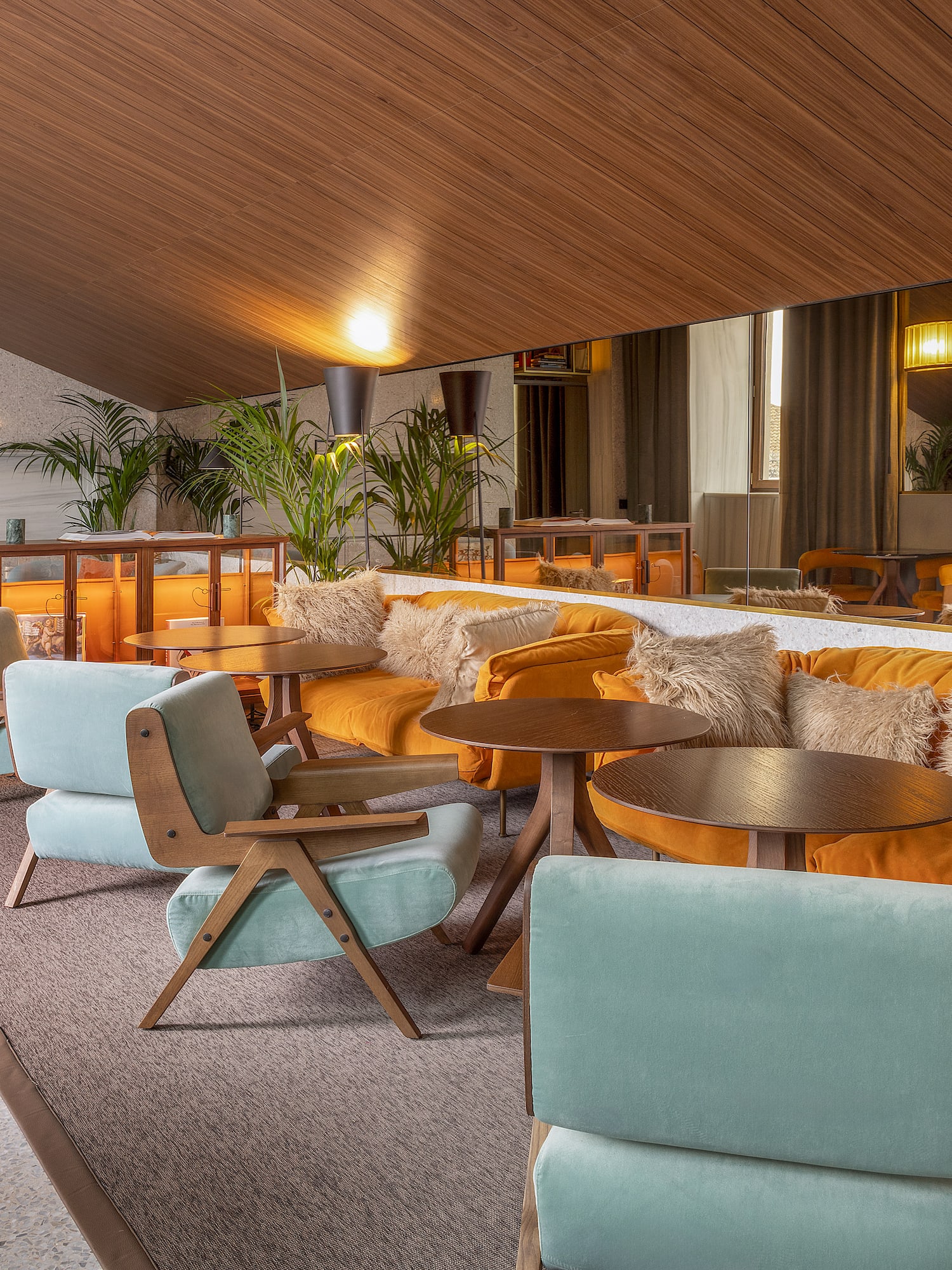 a room with a large mirror and tables and chairs