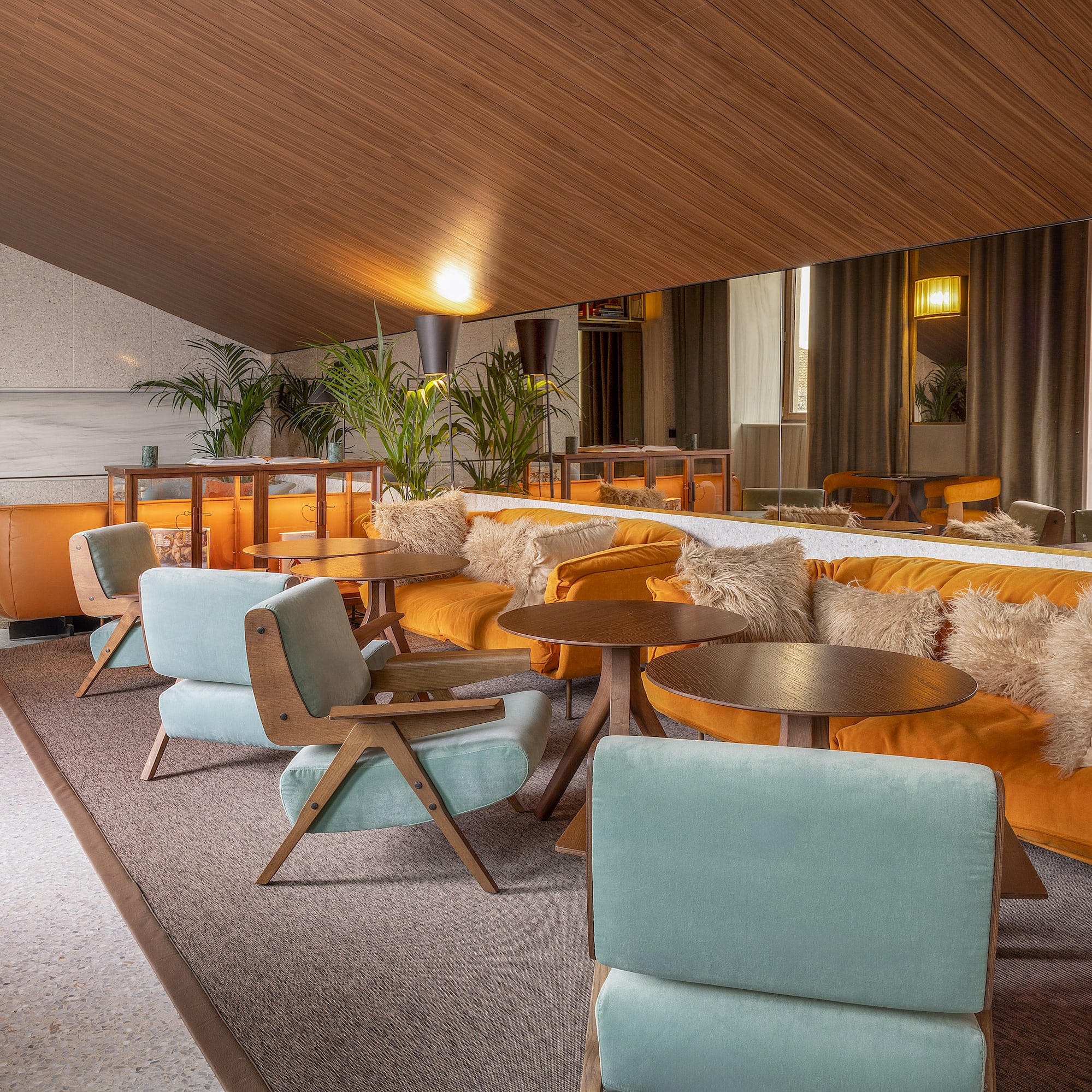a room with a large mirror and tables and chairs
