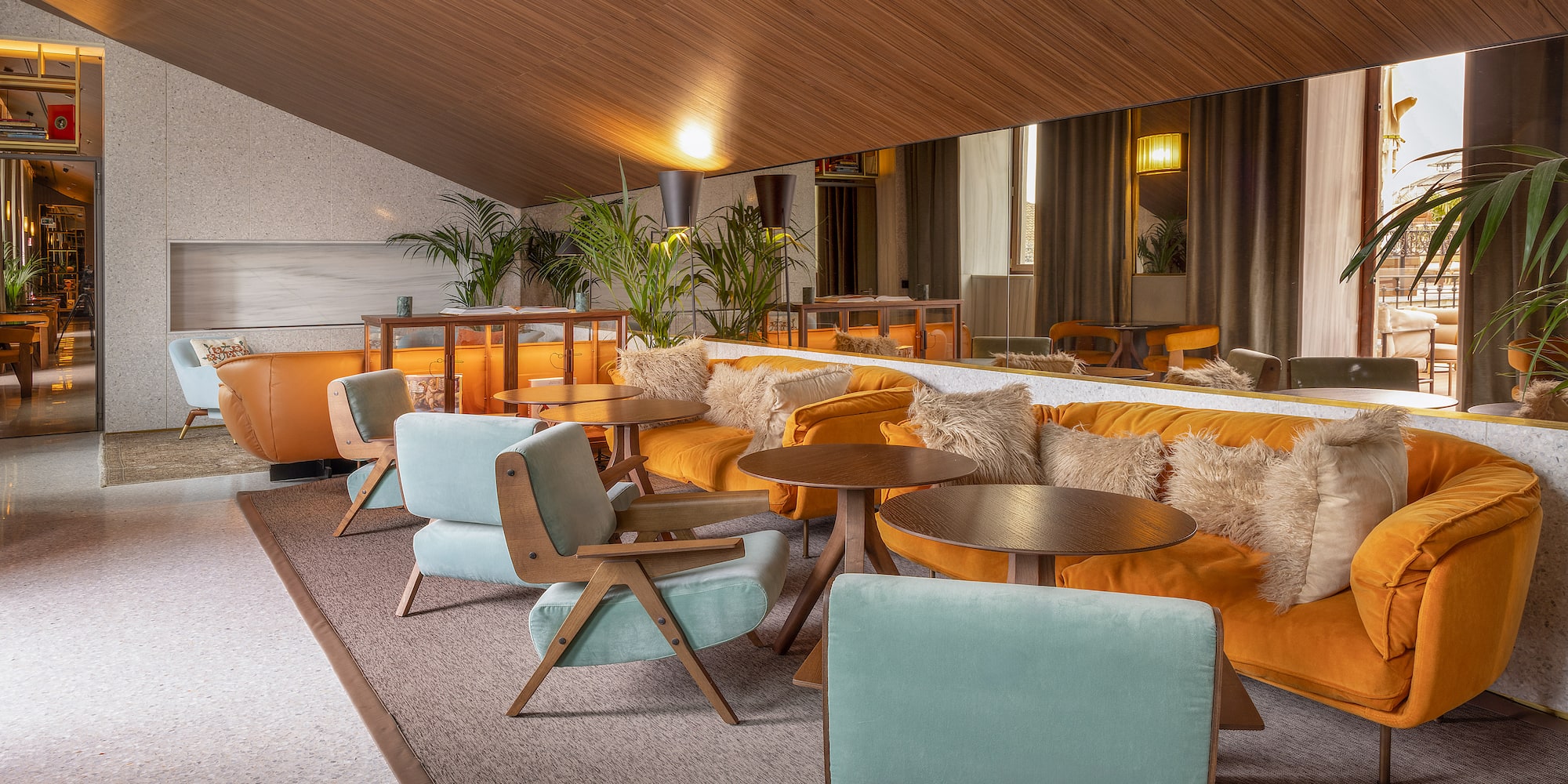 a room with a large mirror and tables and chairs