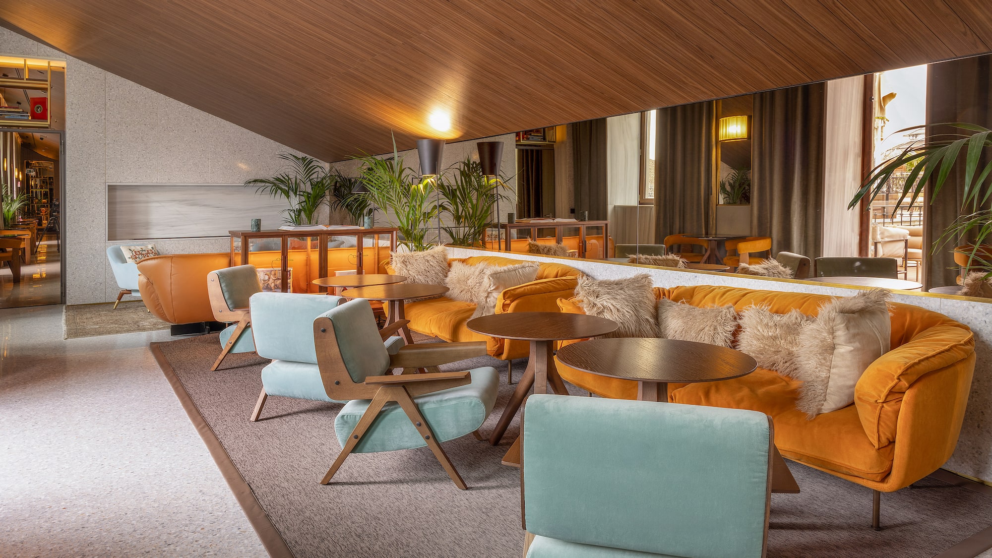 a room with a large mirror and tables and chairs