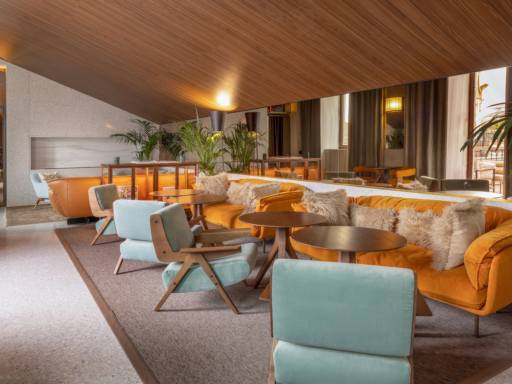 a room with a large mirror and tables and chairs