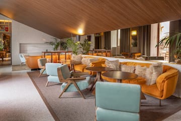 a room with a large mirror and tables and chairs