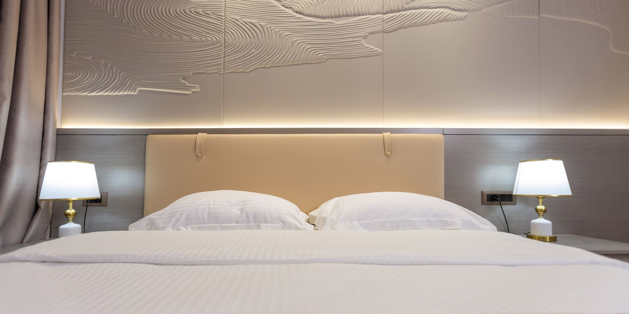 a bed with a lamp and a wall