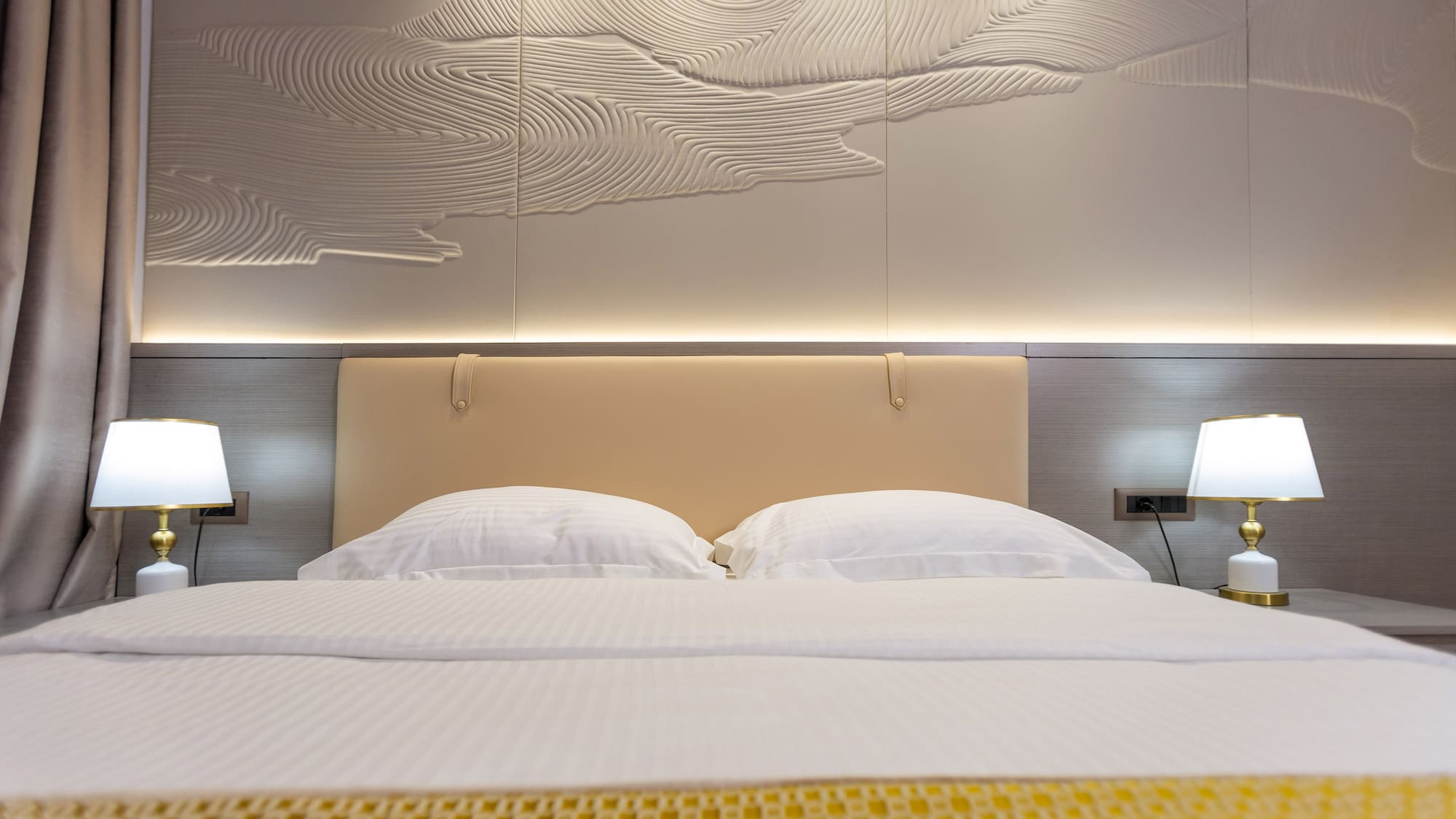 a bed with a lamp and a wall