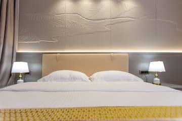 a bed with a lamp and a wall