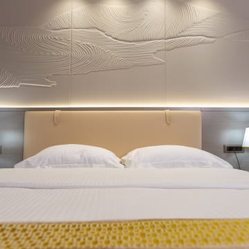 a bed with a lamp and a wall