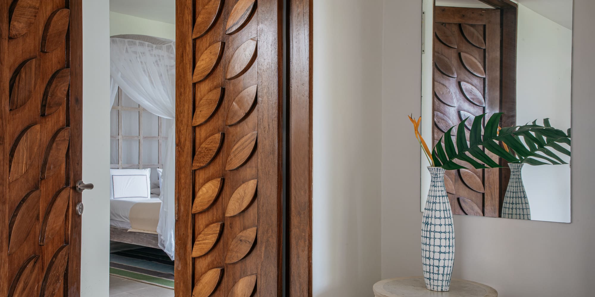 a room with a door and a vase of flowers