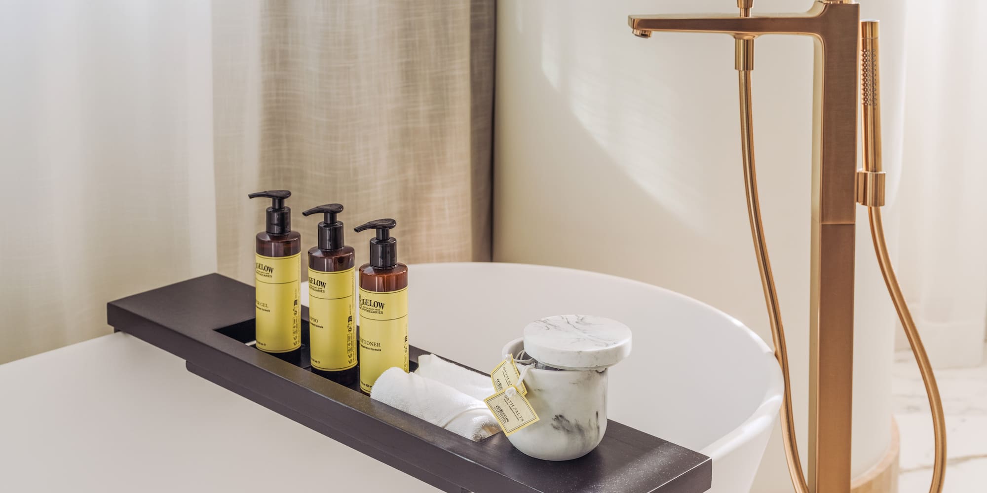 a bathtub with a tray of soap and a container of cream