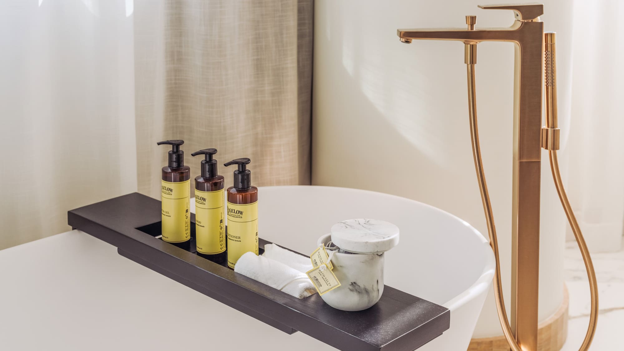 a bathtub with a tray of soap and a container of cream