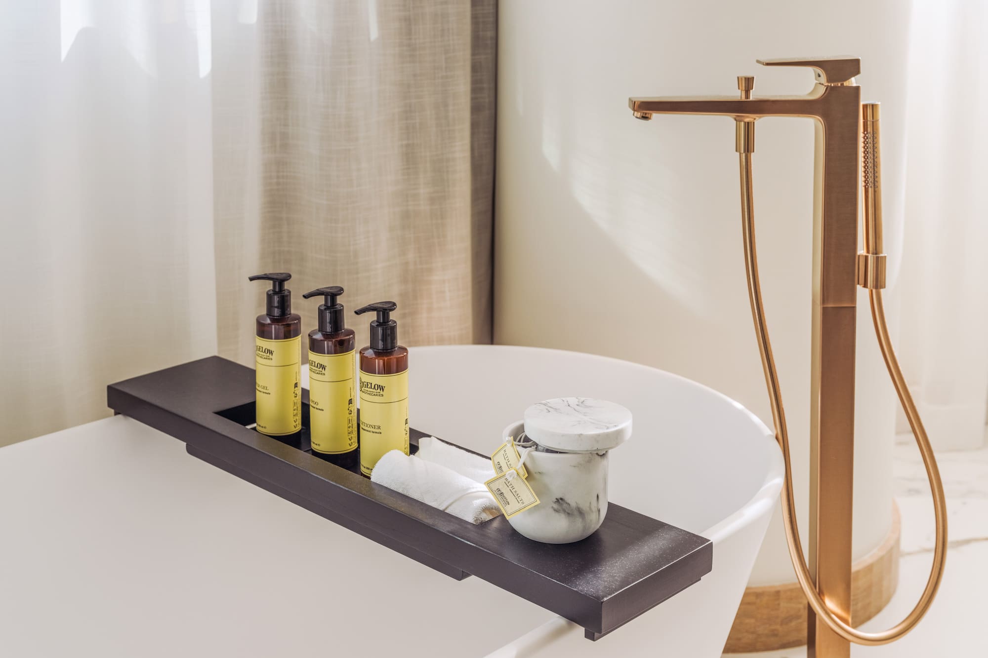 a bathtub with a tray of soap and a container of cream