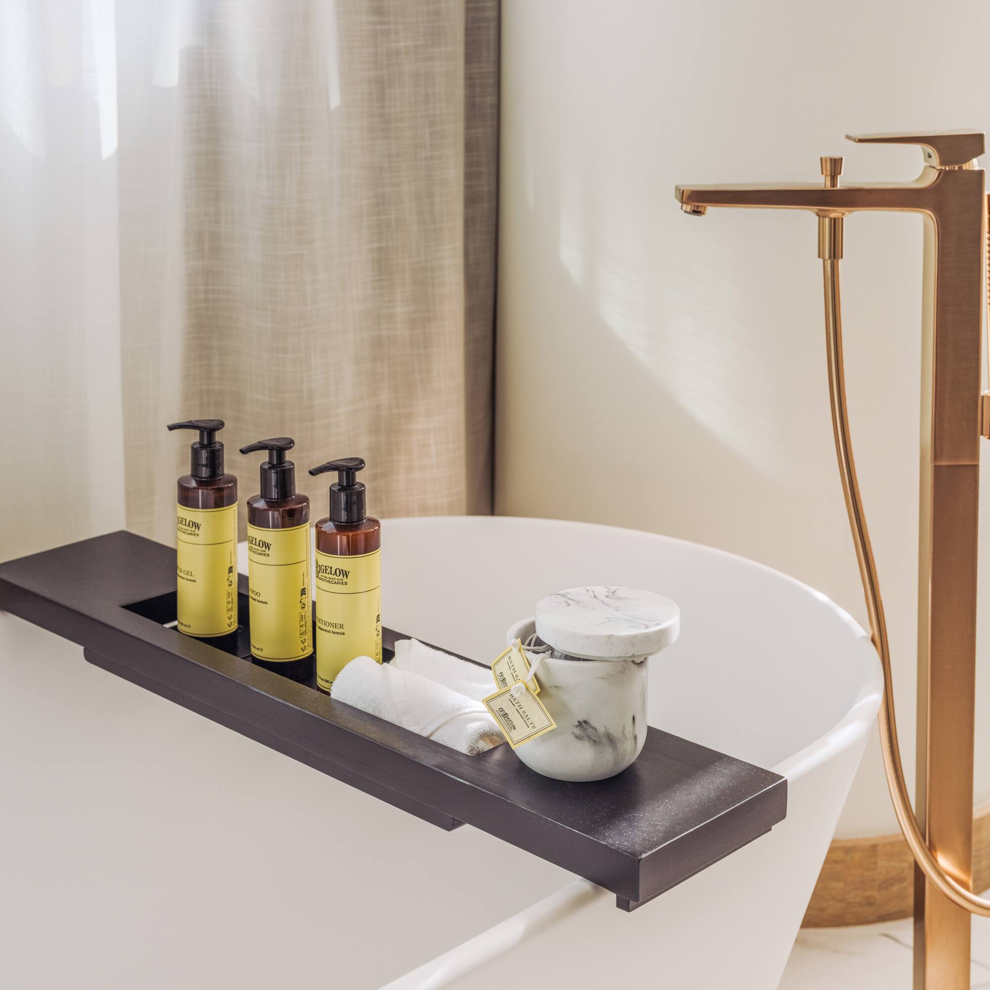 a bathtub with a tray of soap and a container of cream