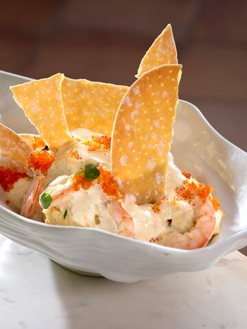 a bowl of food with shrimp and chips