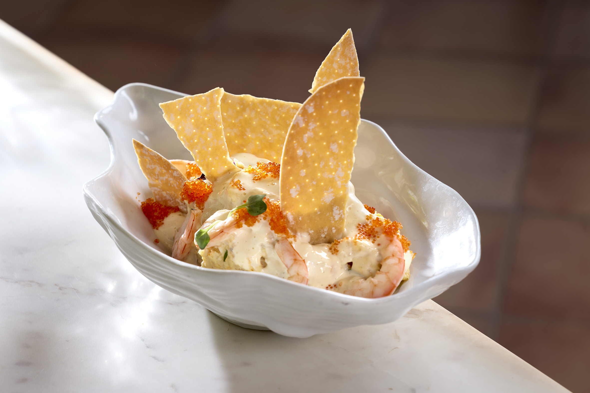 a bowl of food with shrimp and chips