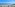 Sunny beach with blue ocean, palm trees, and coastal road.