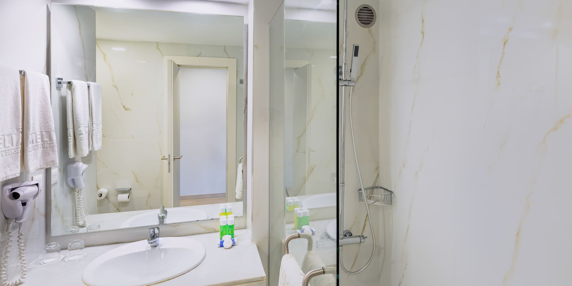 a bathroom with a glass shower and sink