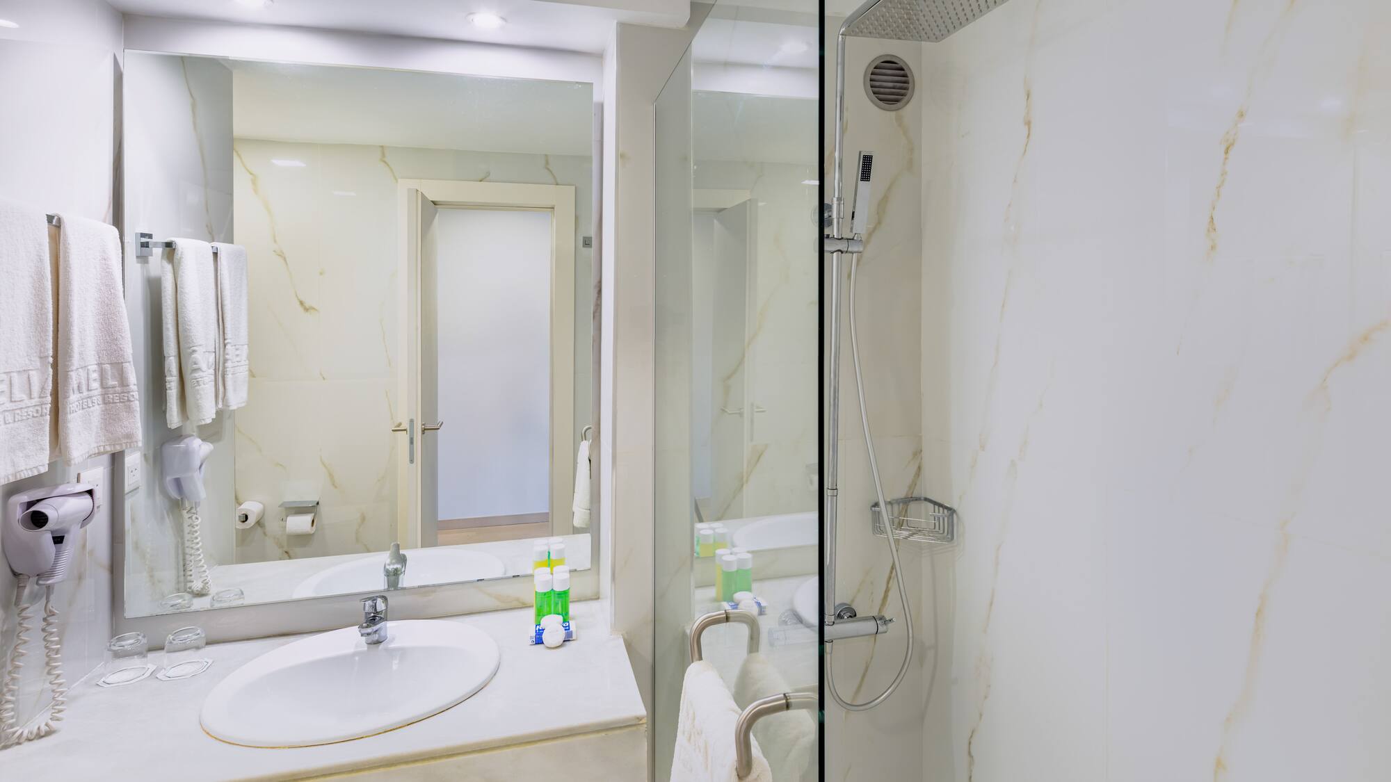a bathroom with a glass shower and sink