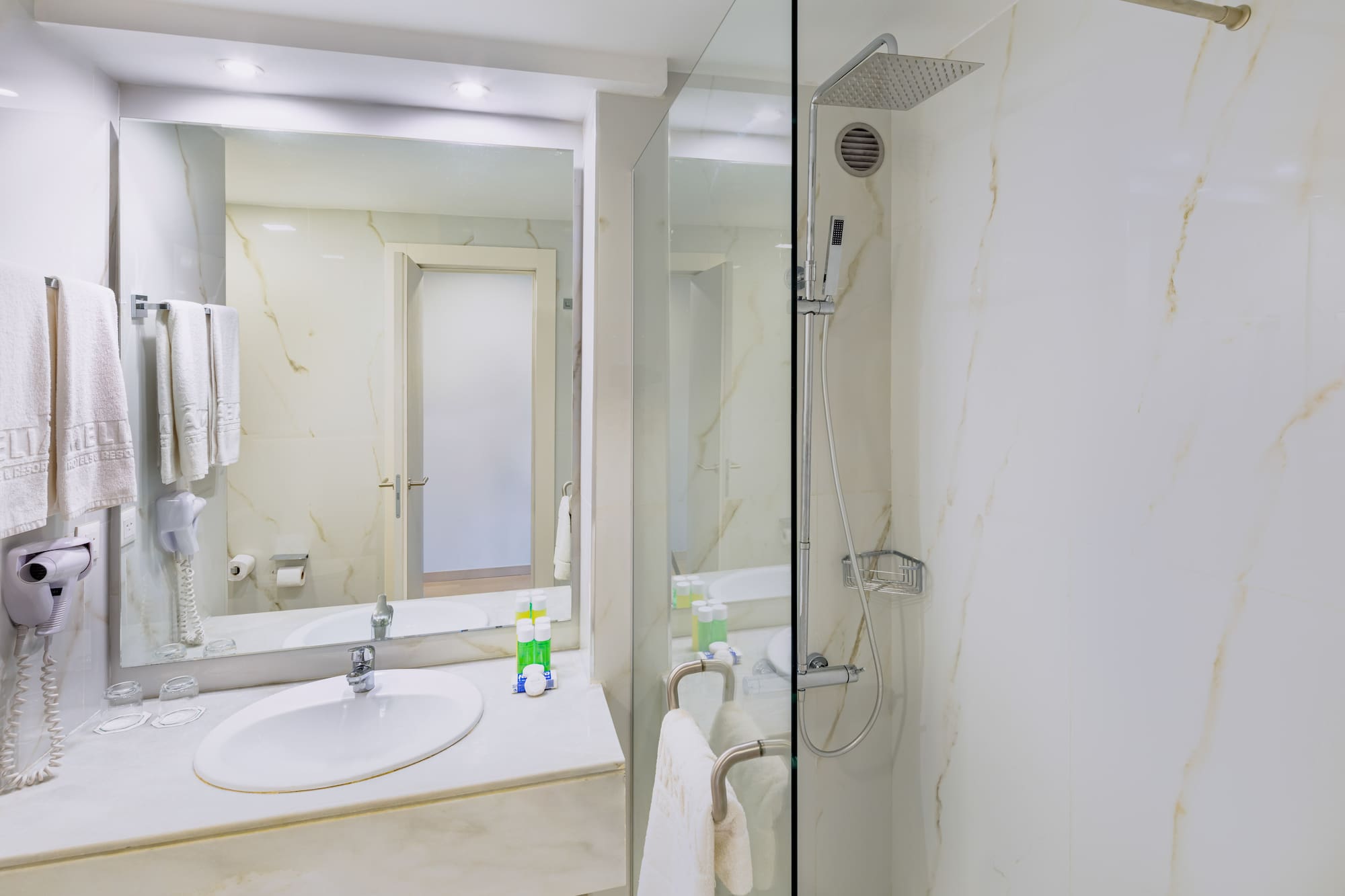 a bathroom with a glass shower and sink