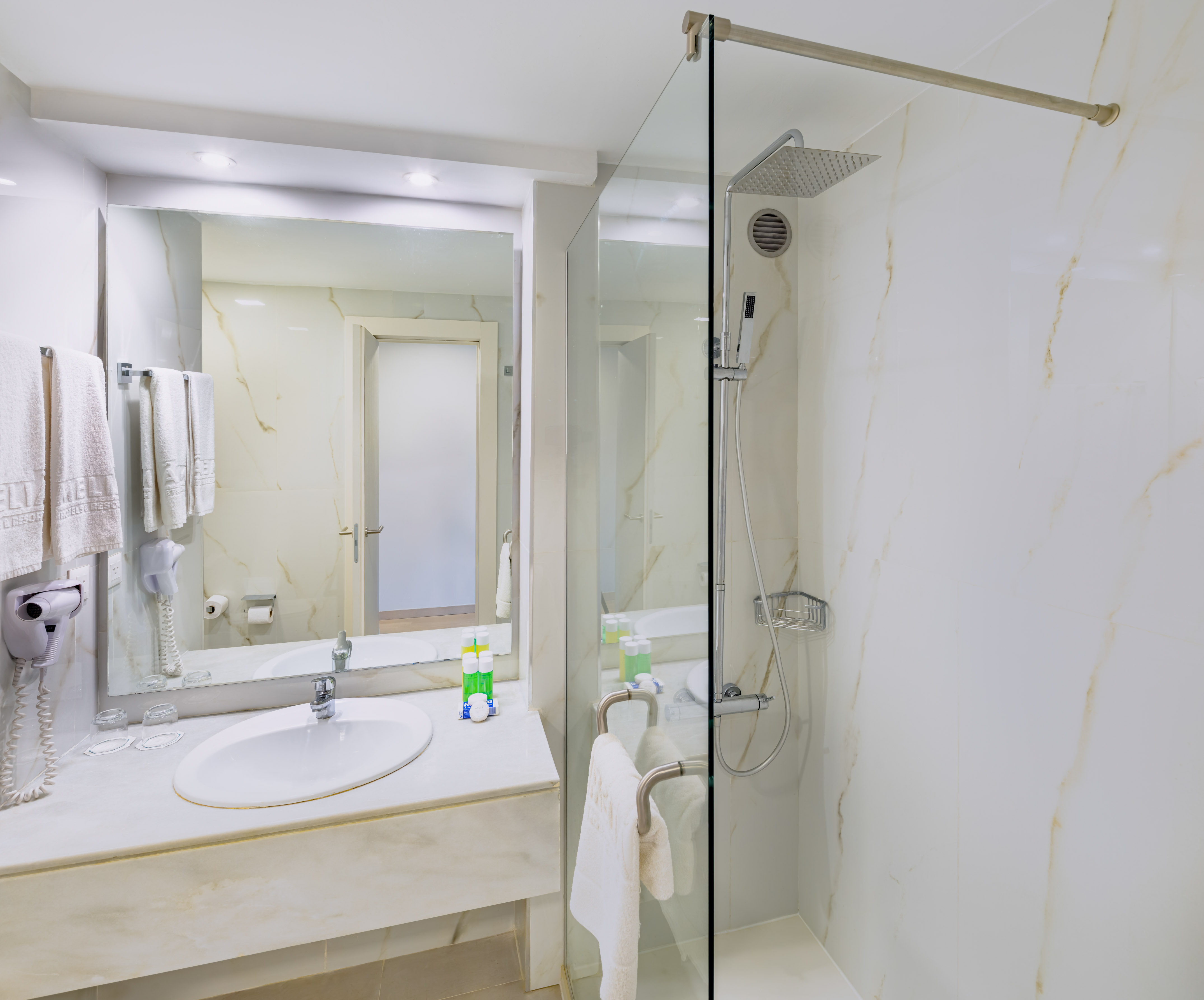 a bathroom with a glass shower and sink