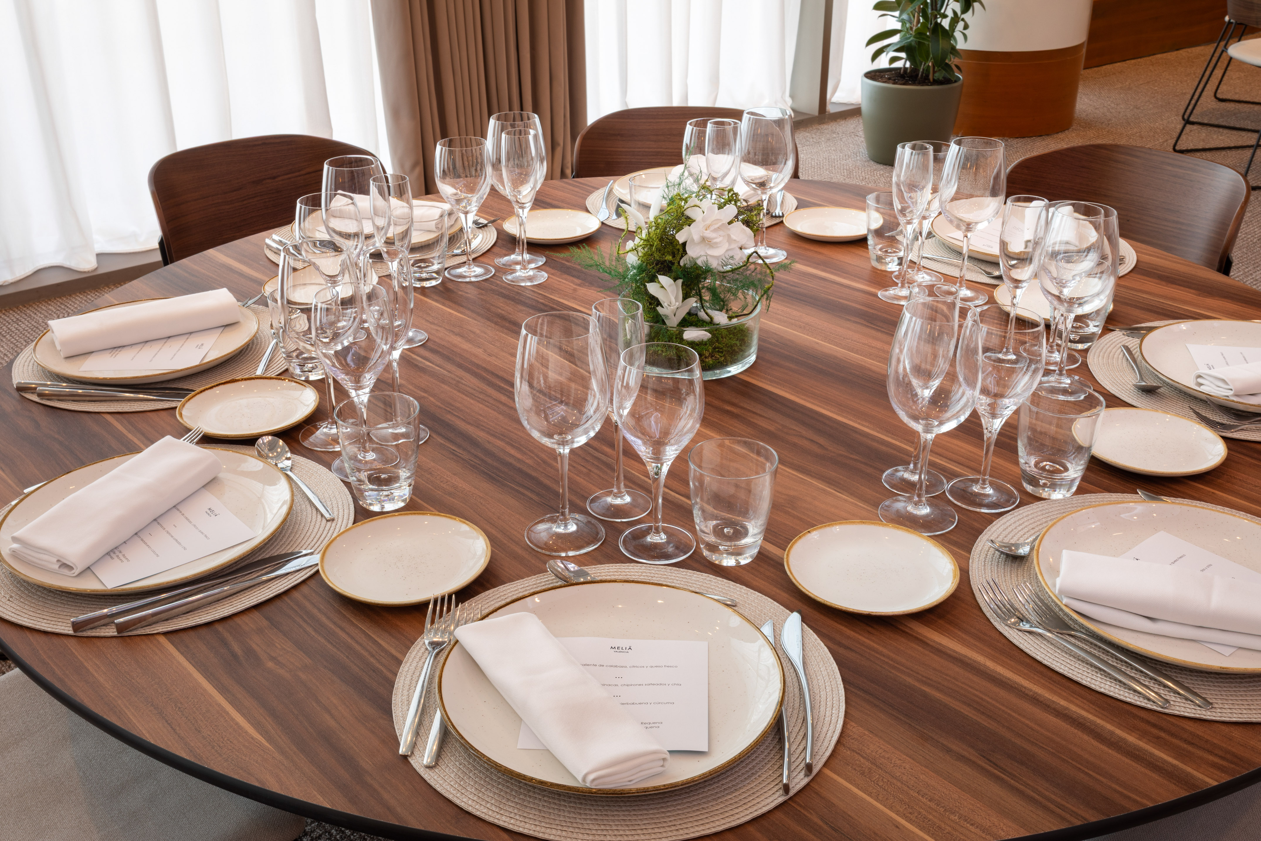 Meliá event dining table with elegant place settings and floral centerpiece.