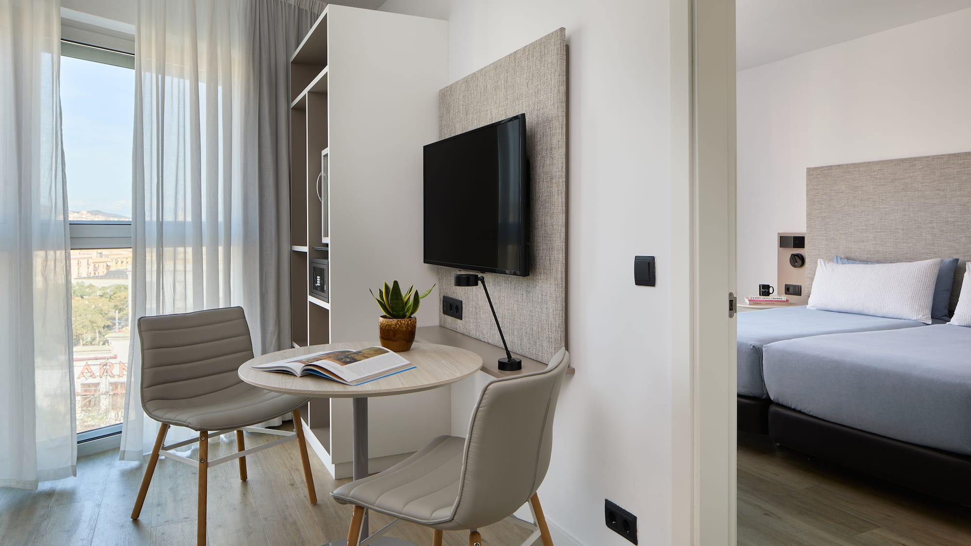 a room with a table and chairs and a tv