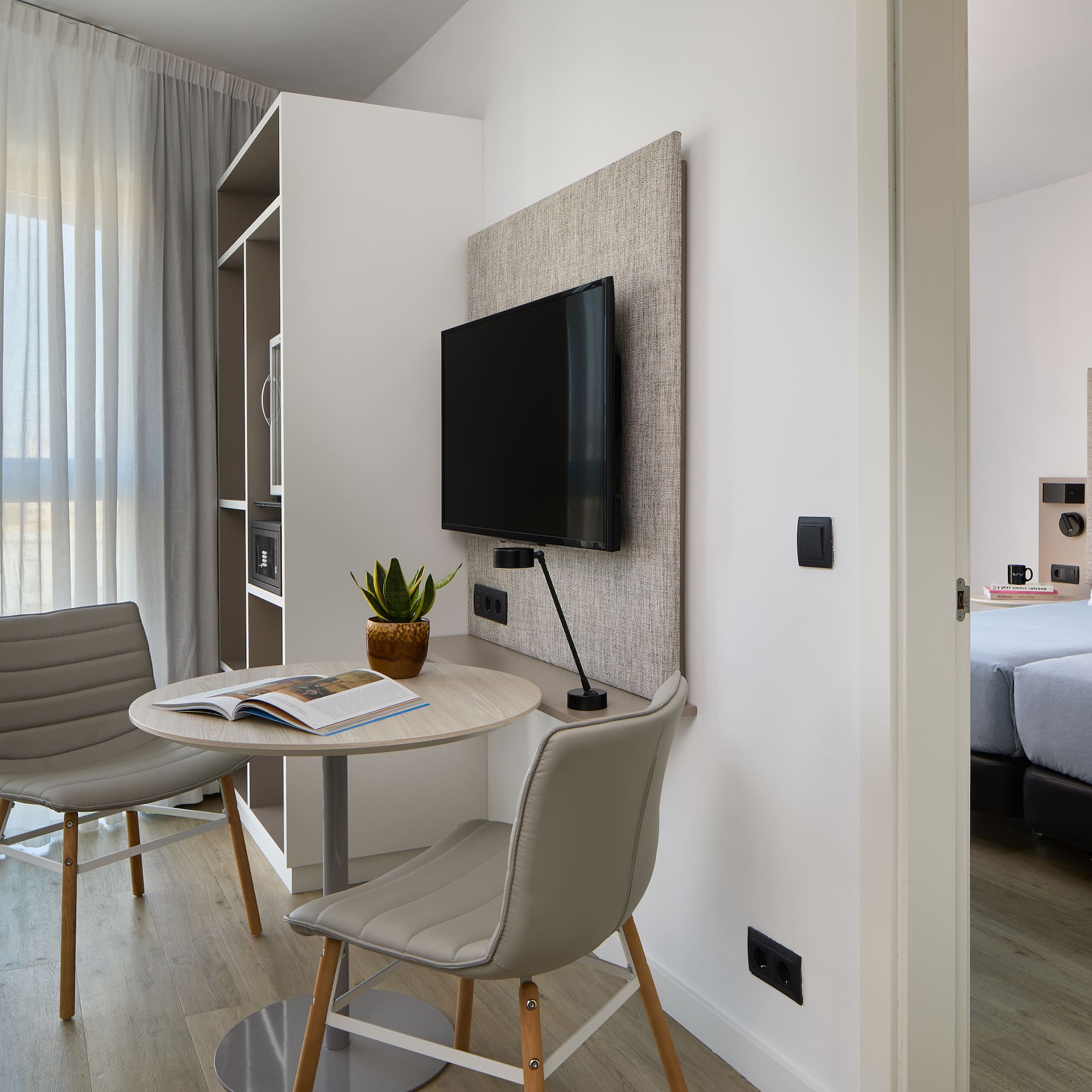 a room with a table and chairs and a tv