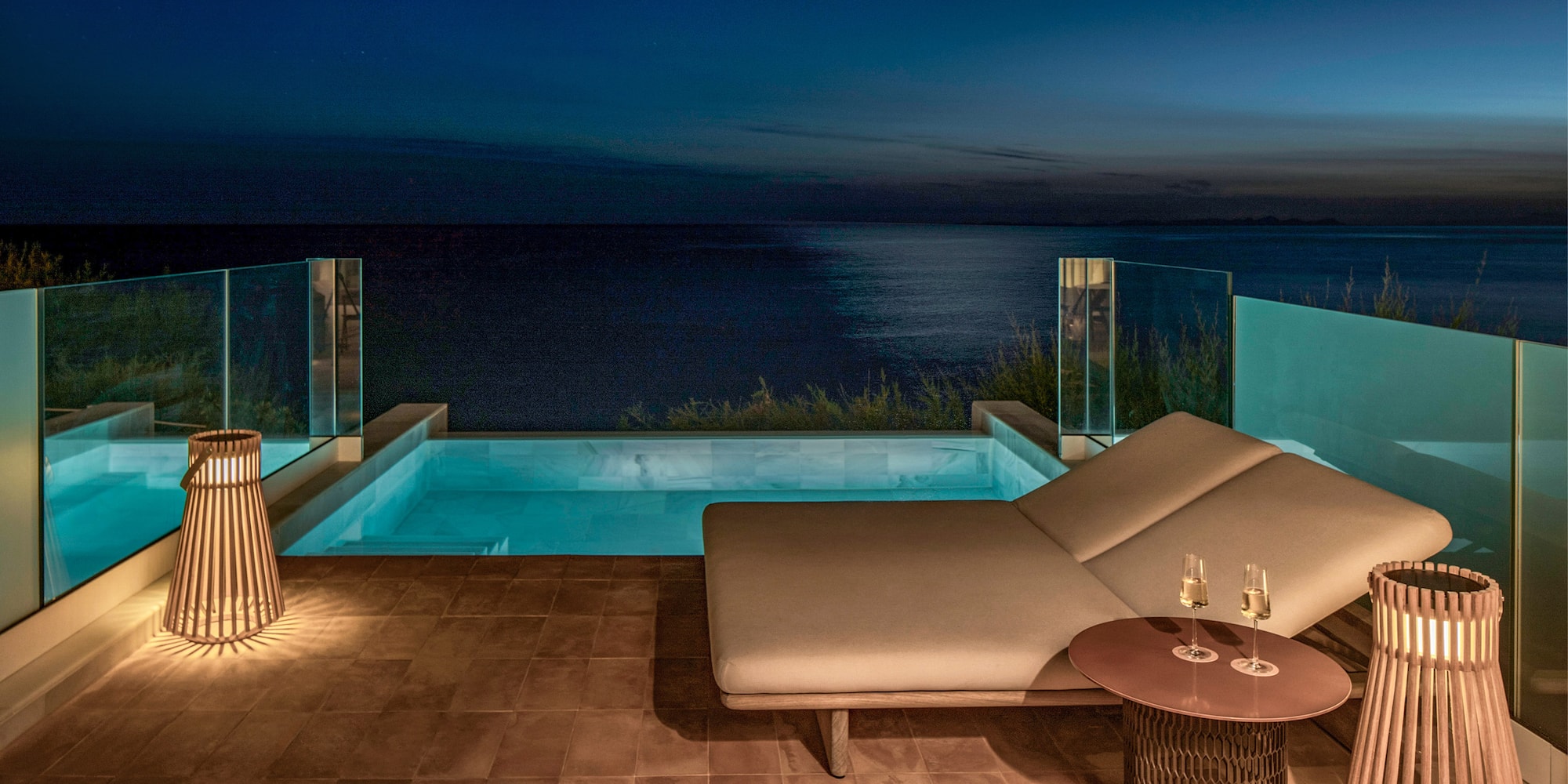 Luxury private pool balcony with ocean view at night, moon and stars.