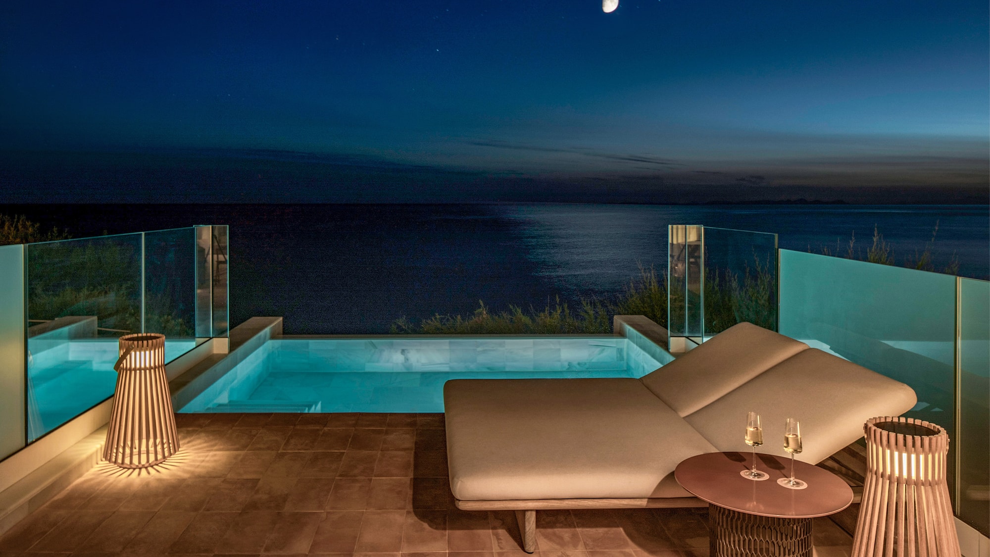 Luxury private pool balcony with ocean view at night, moon and stars.