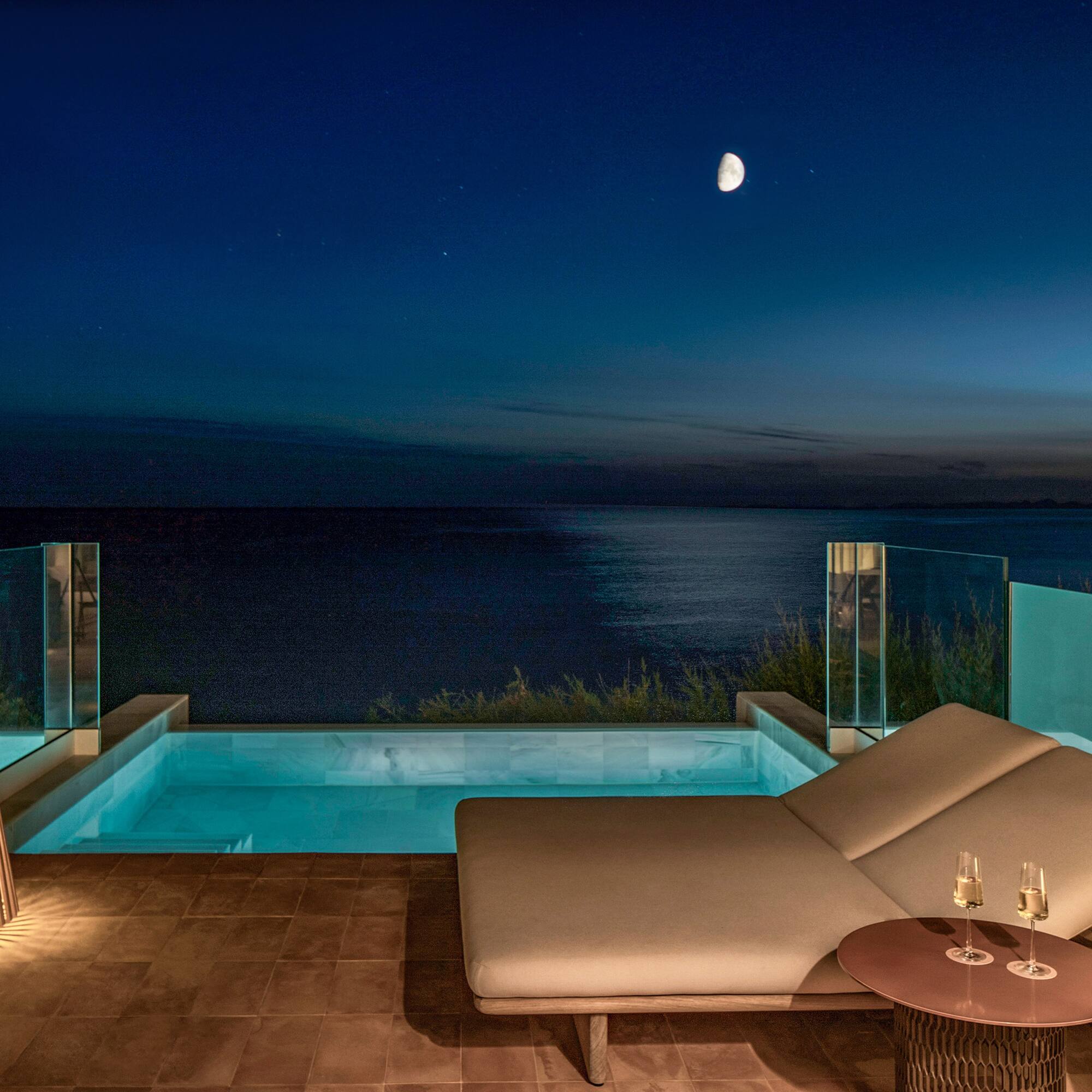 Luxury private pool balcony with ocean view at night, moon and stars.
