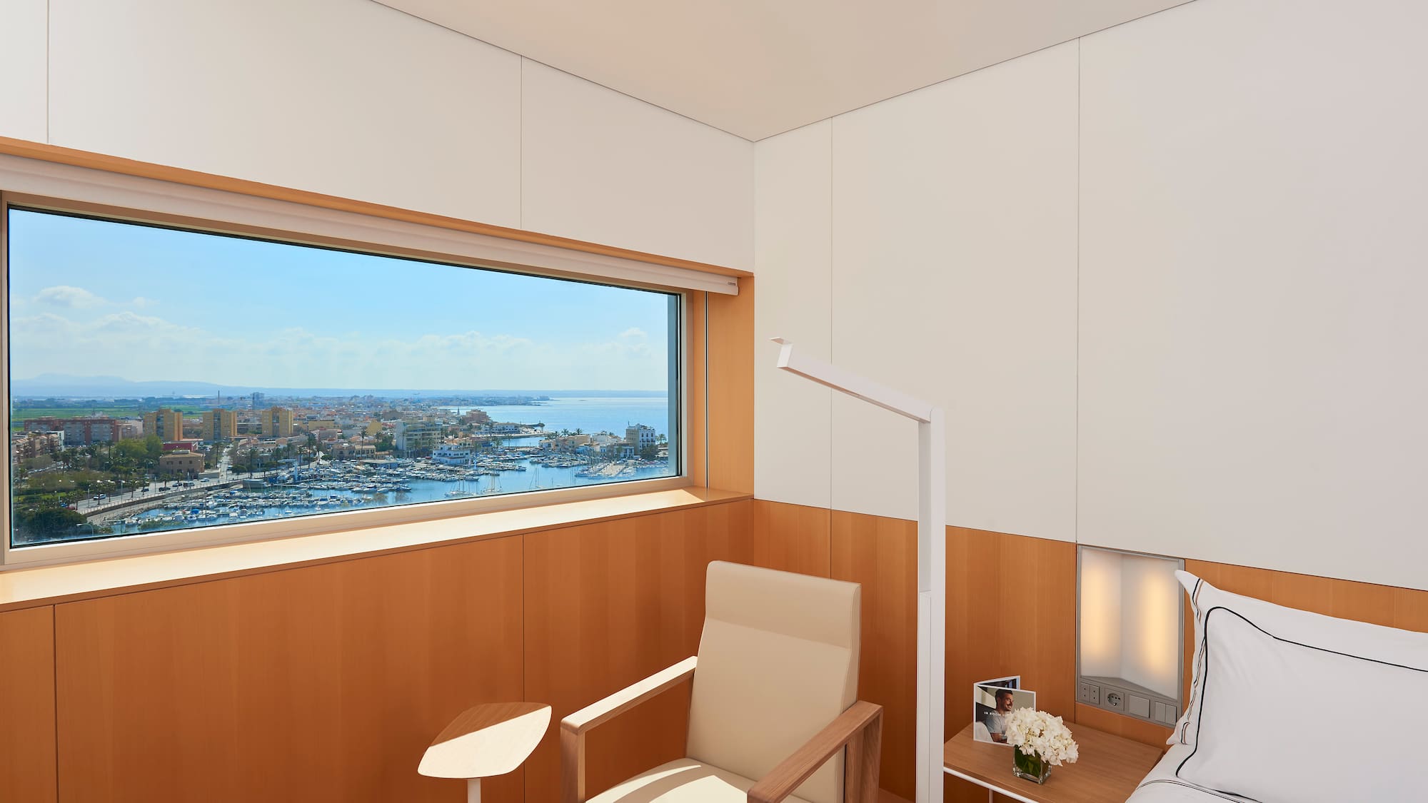 a room with a bed and a window overlooking a city