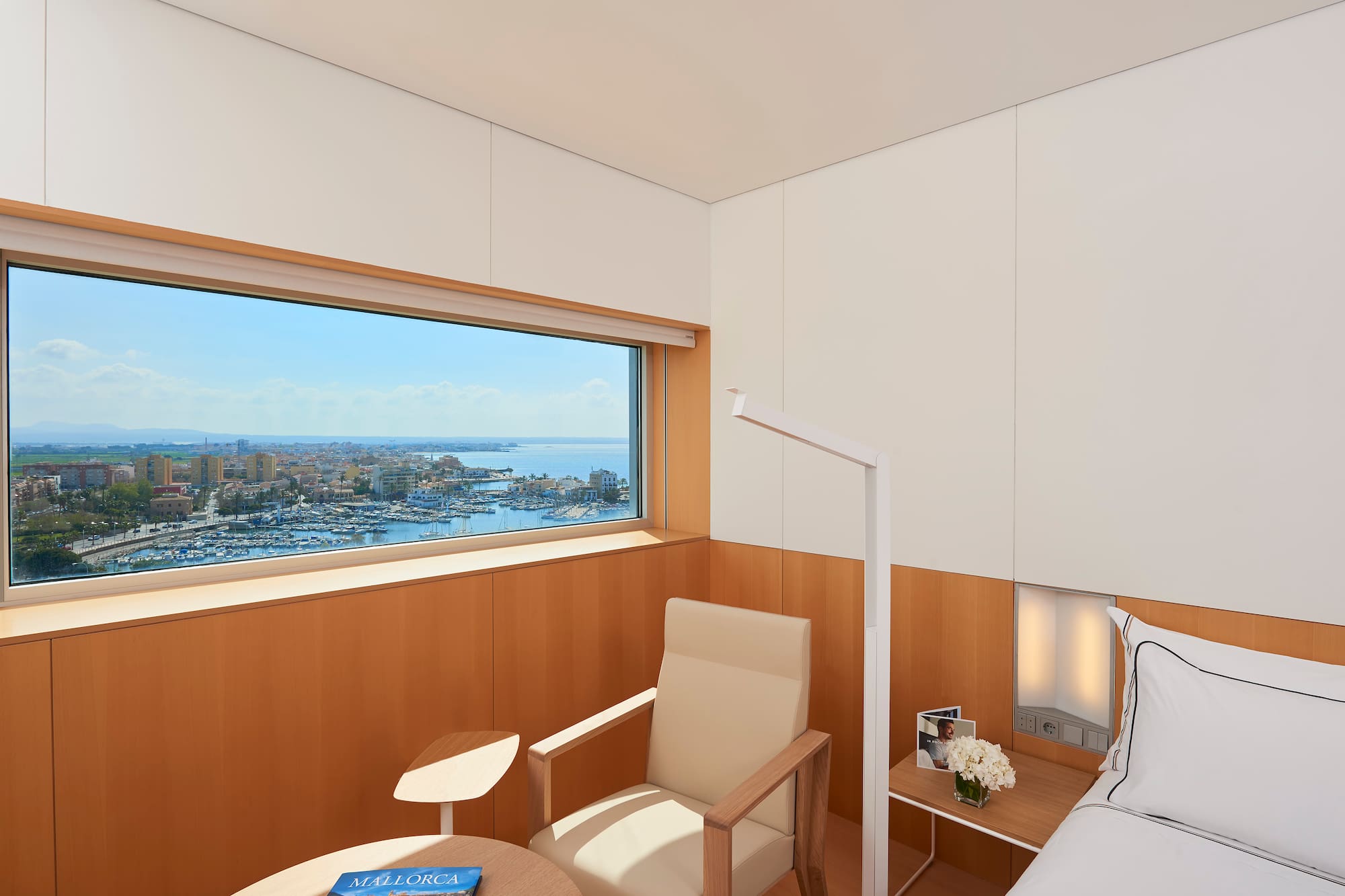 a room with a bed and a window overlooking a city