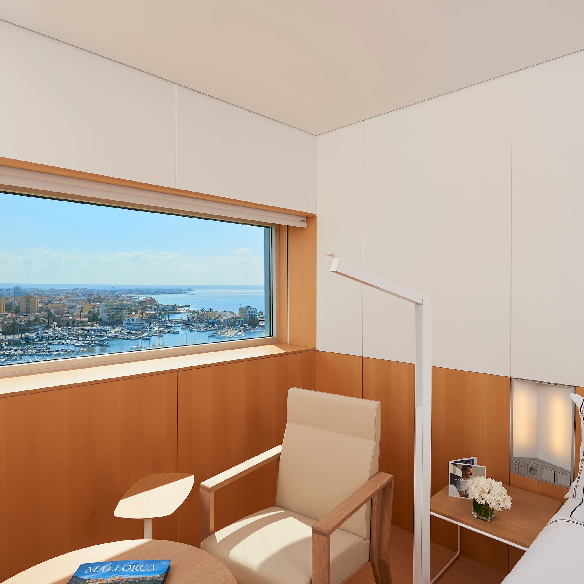 a room with a bed and a window overlooking a city