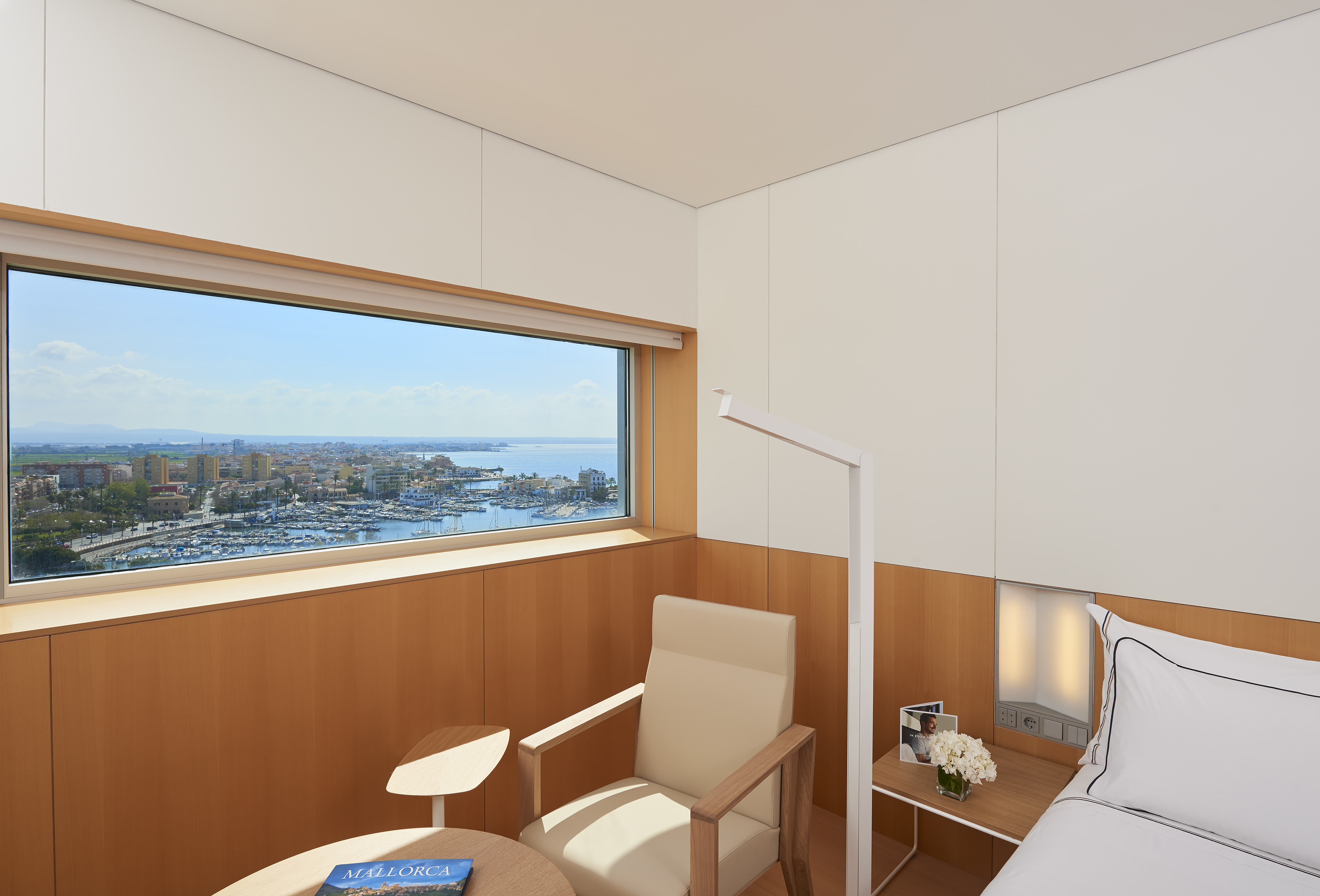 a room with a bed and a window overlooking a city