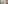 Hotel bedroom with king bed, desk, large window city view, and armchair.