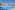 Sunny resort hotel with large outdoor pool, blue sun loungers, and palm trees.