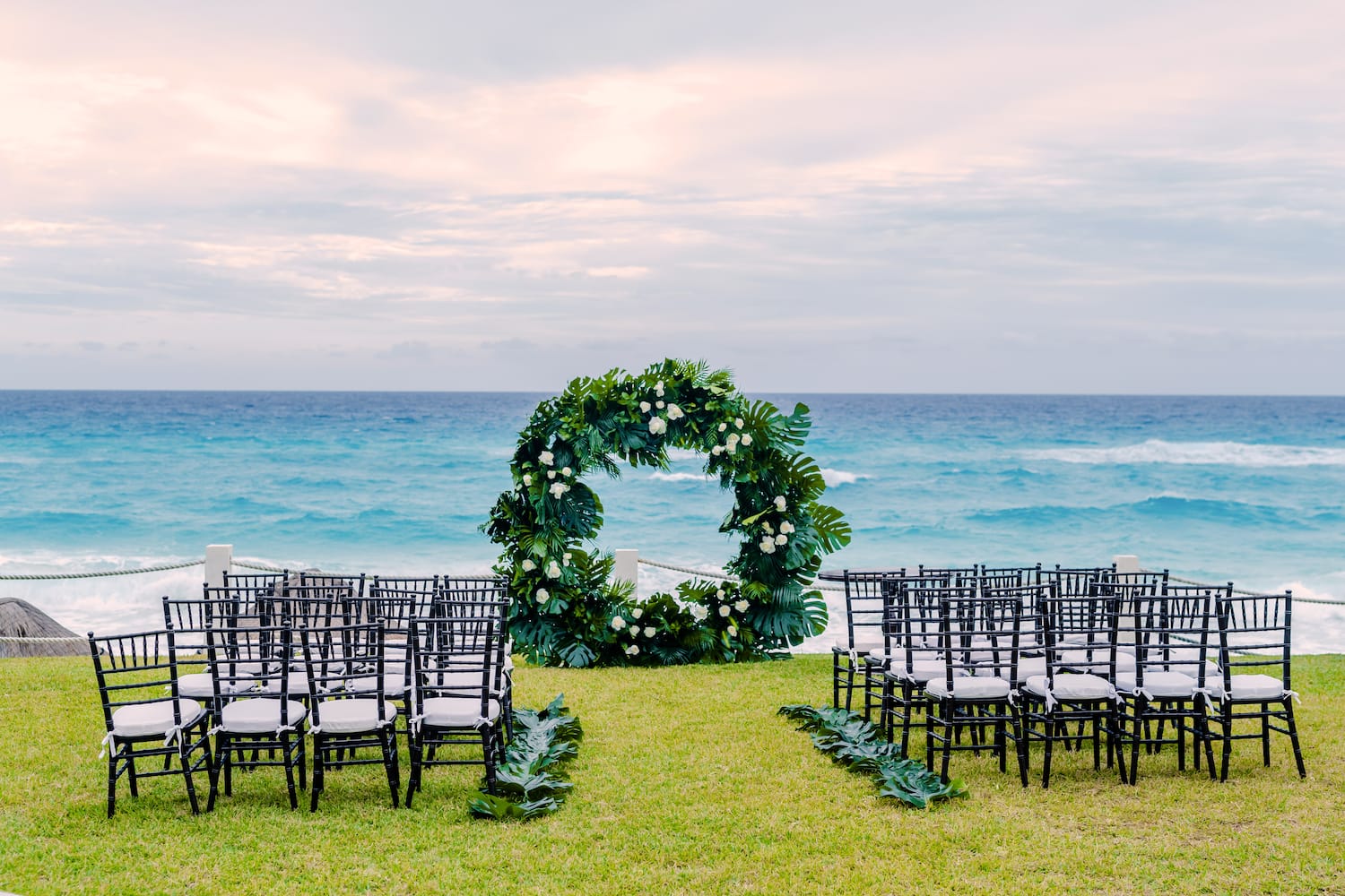 a wedding ceremony set up with chairs and a wreath
