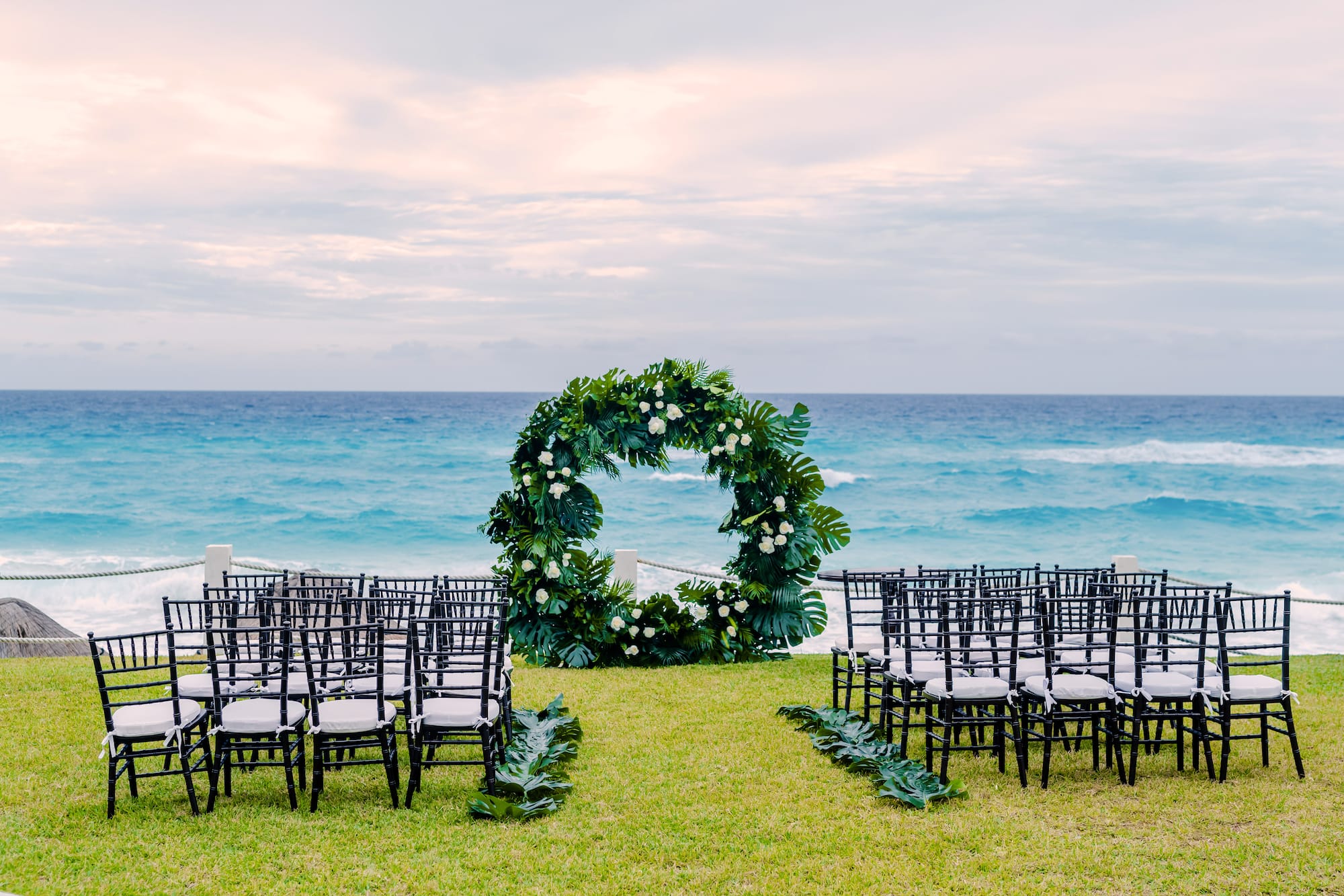 a wedding ceremony set up with chairs and a wreath