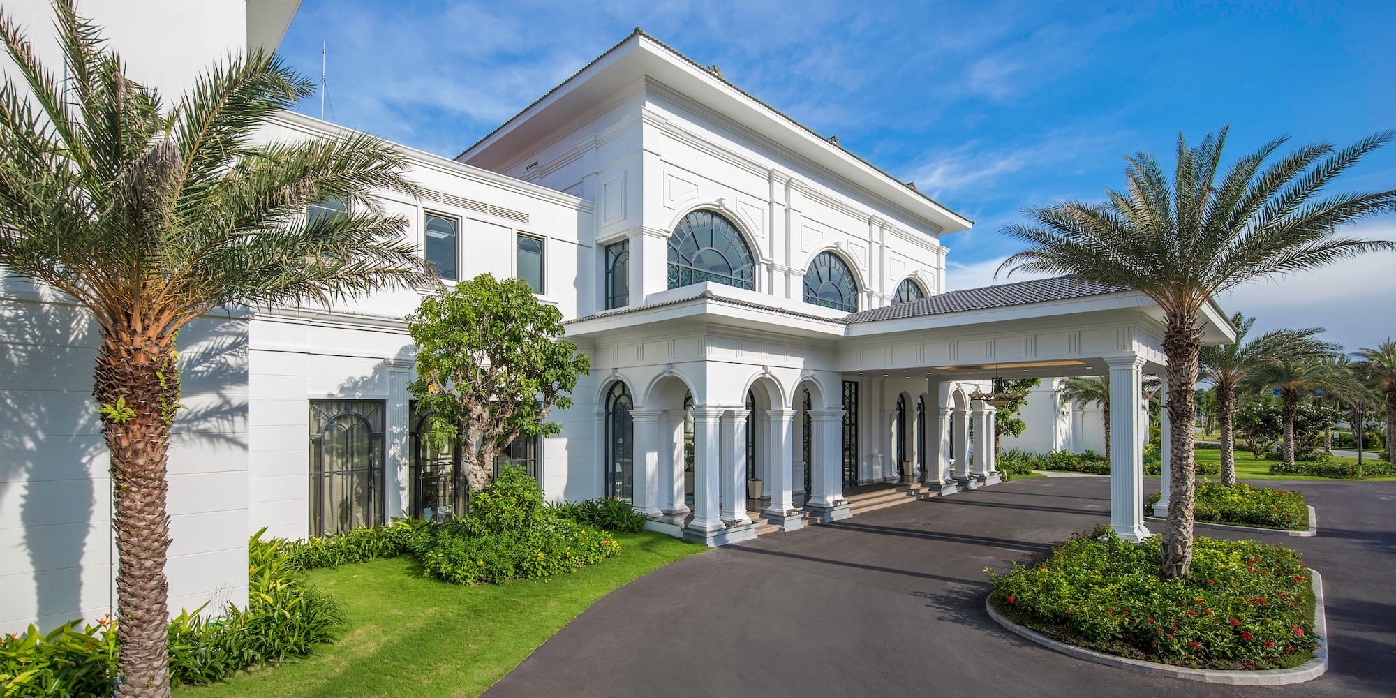 a white building with columns and a driveway